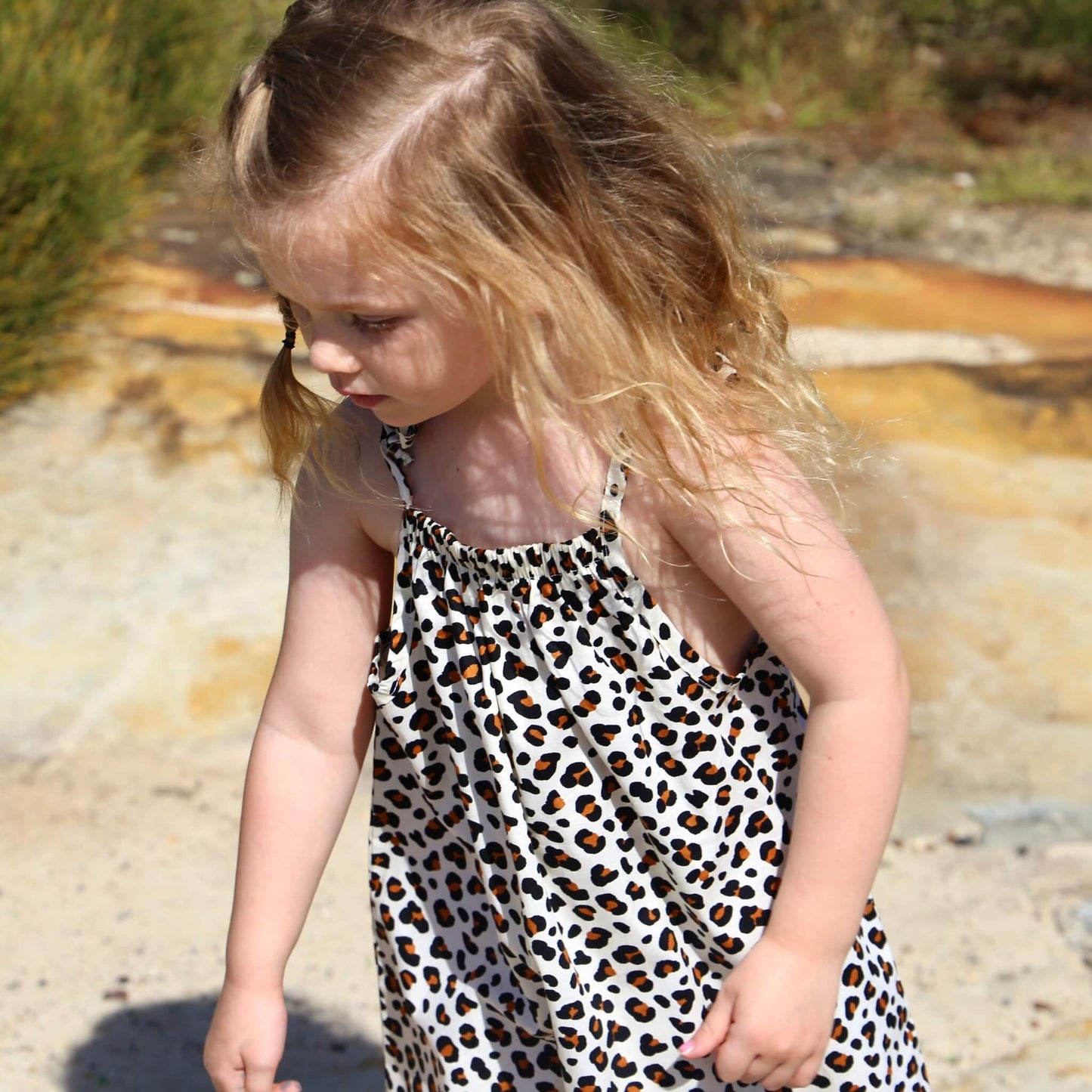 girl wearing animal printed cotton poplin a-line dress with shoulder strap ties. Ethically made in australia with 100% printed cotton poplin
