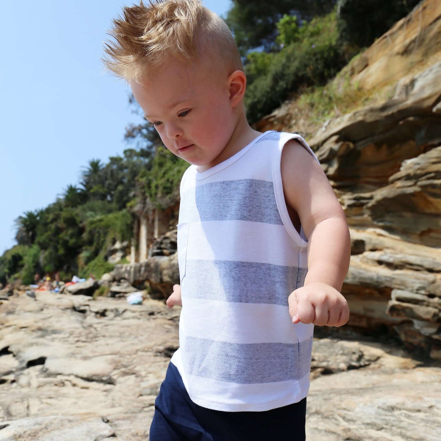 toddler boy wearing navy/white stripe singlet with front pocket. Ethically made in australia with 100% cotton jersey