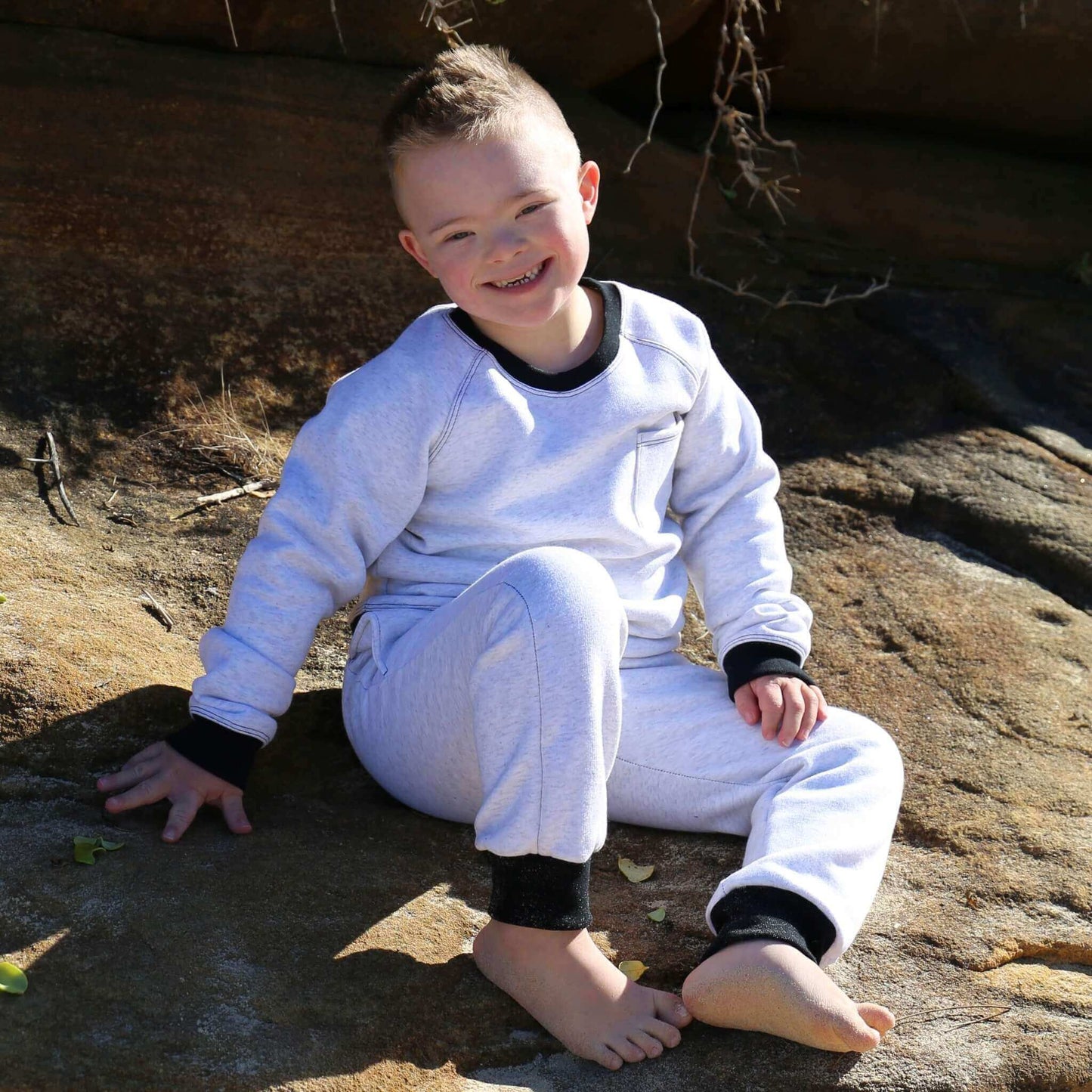 Boy wearing White Marle Winter Sweater featuring Black contrast rib at neck, hem and cuff with front pocket ethically made in Australia with Cotton blend cosy and warm Fleece
