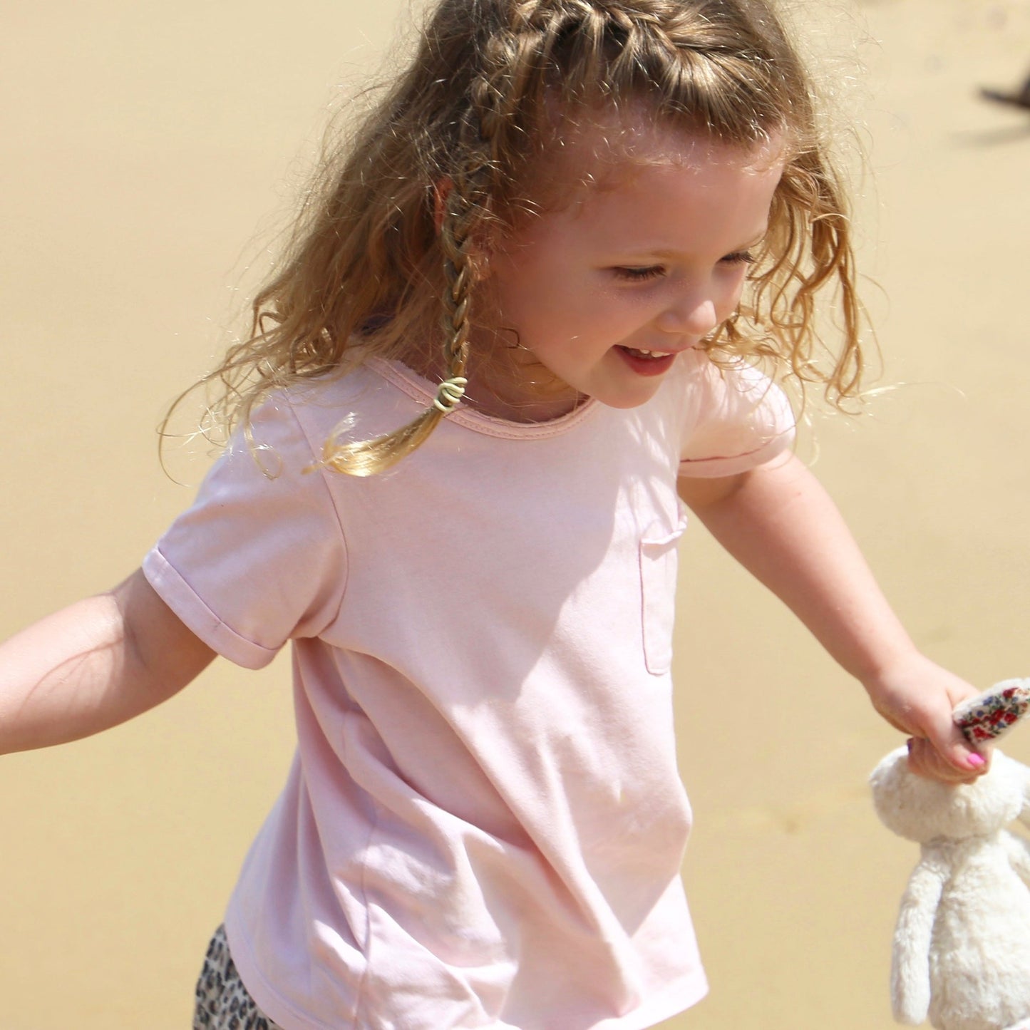 giro wearing pale pink short sleeve tshirt featuring front pocket, turned up cuffs and raw edge neckline. Ethically made in australia with 100% cotton jersey