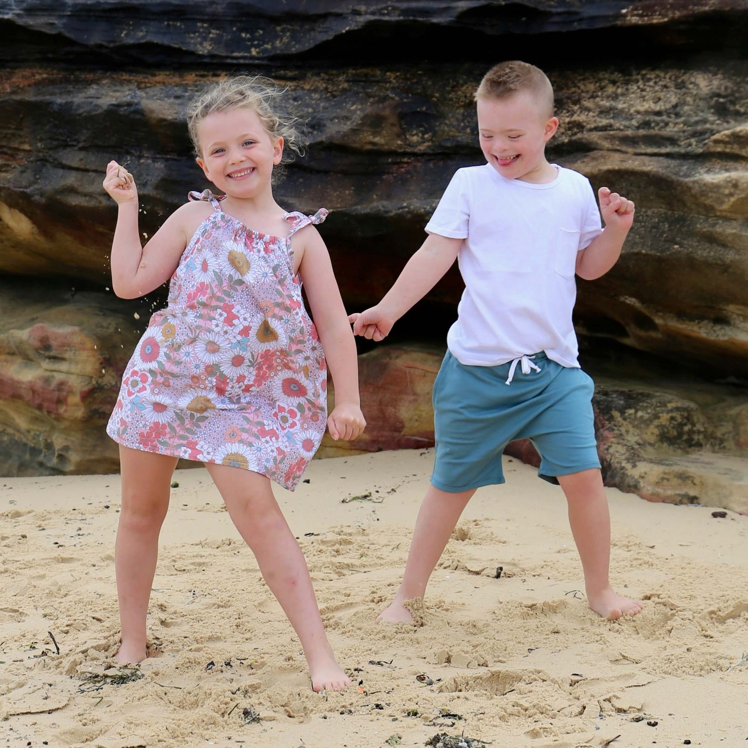 girl wearing floral printed cotton summer dress and boy wearing white cotton tshirt with ocean colour cotton jersey drop crotch shorts