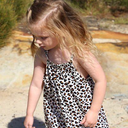 girl wearing animal printed cotton poplin a-line dress with shoulder strap ties.  Ethically made in australia with 100% printed cotton poplin