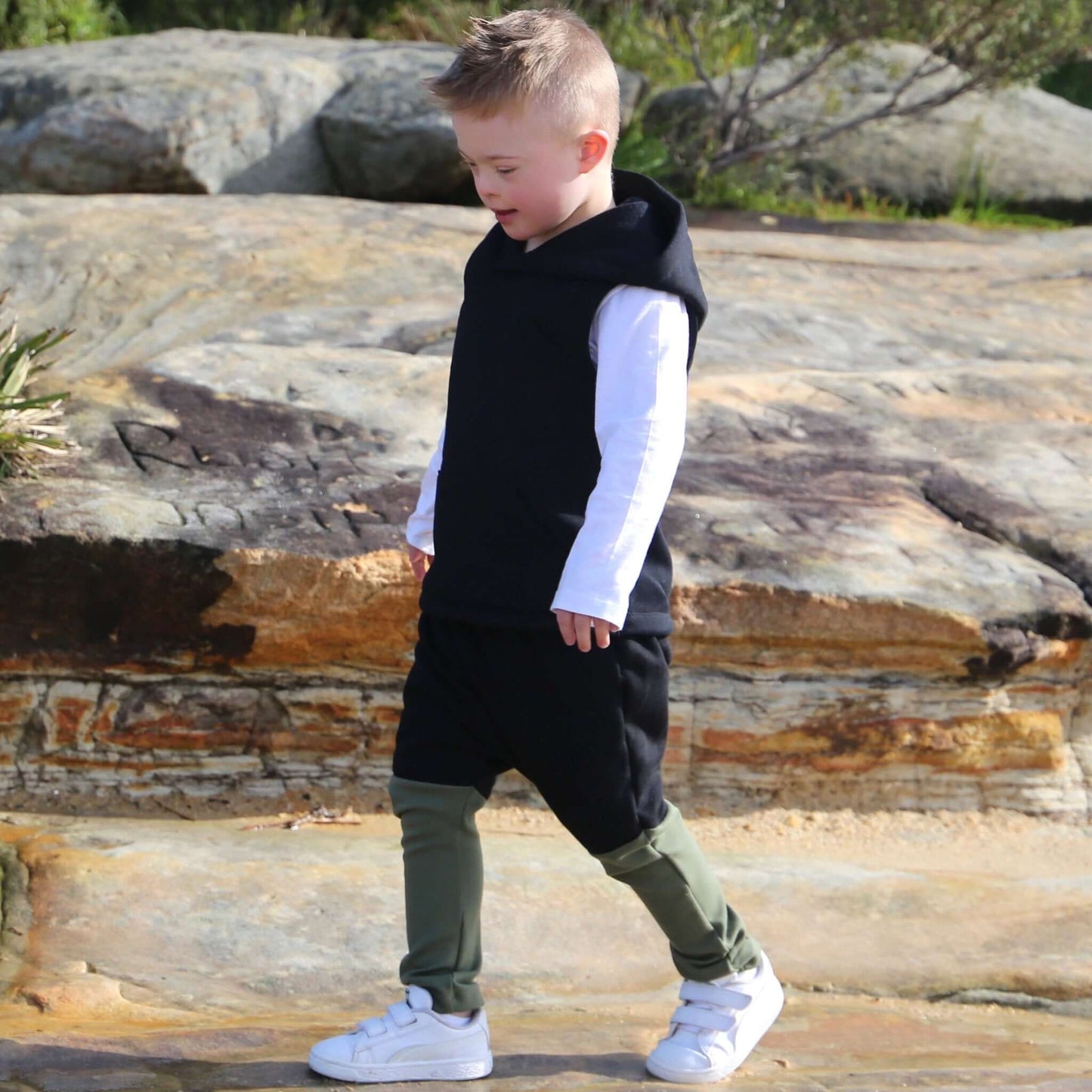 boy wearing black with khaki contrast harem pant featuring an elastic waistband. Ethically made in australia with 100% cotton french terry and contrast ponte fabric