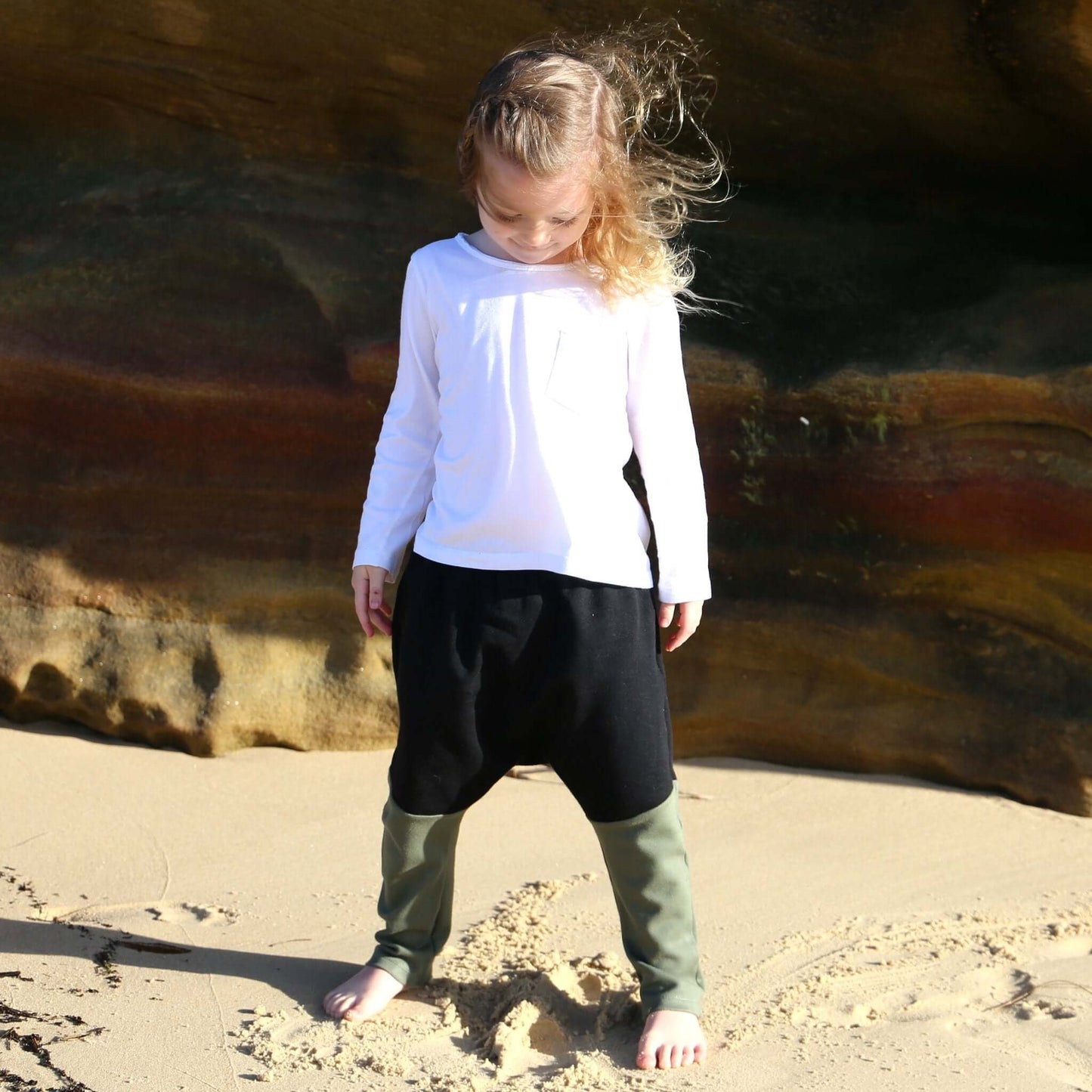 boy wearing black with khaki contrast harem pant featuring an elastic waistband. Ethically made in australia with 100% cotton french terry and contrast ponte fabric