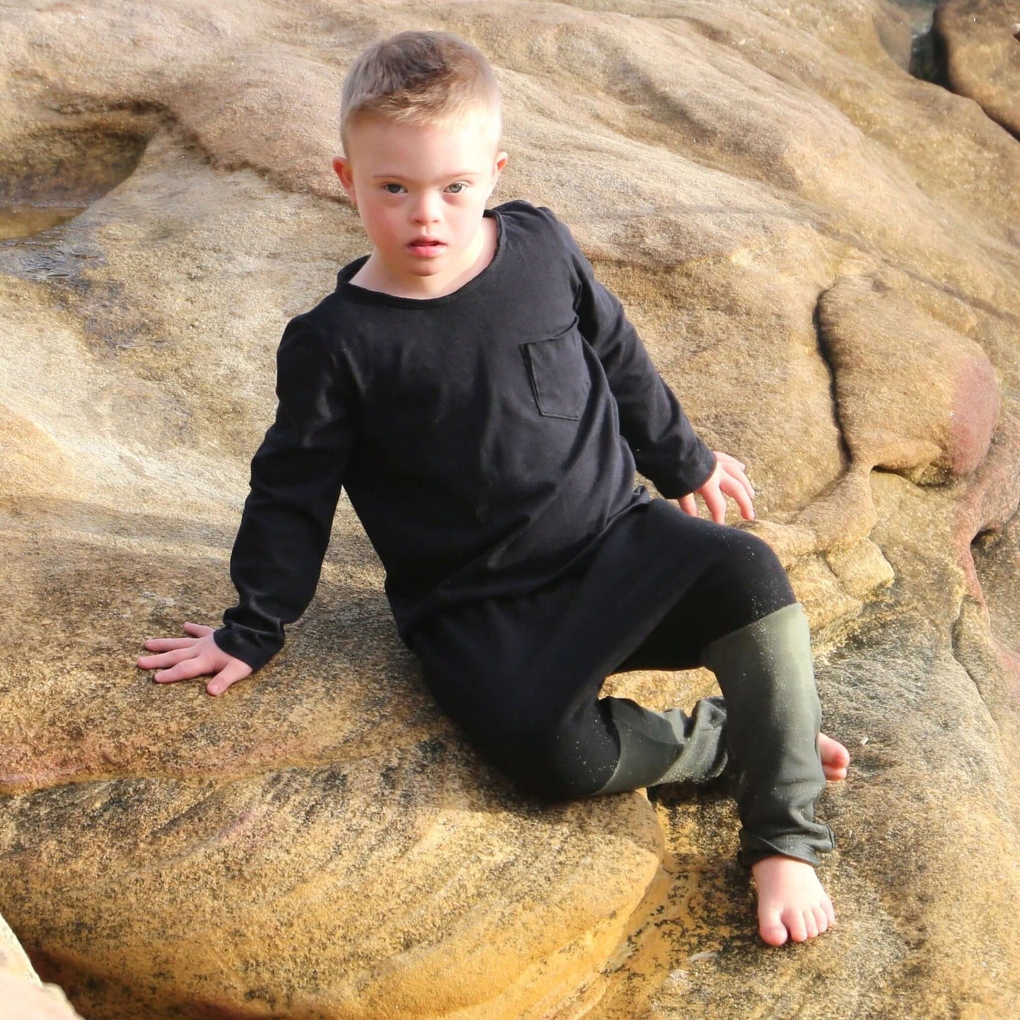 boy wearing black with khaki contrast harem pant featuring an elastic waistband. Ethically made in australia with 100% cotton french terry and contrast ponte fabric