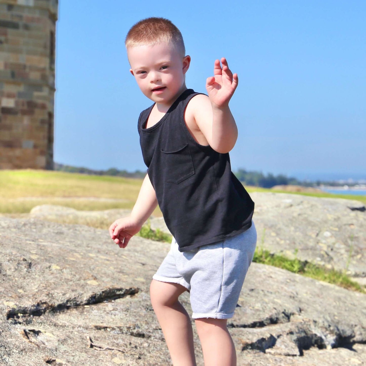 toddler boy wearing black singlet with front pocket. Ethically made in australia with 100% cotton jersey