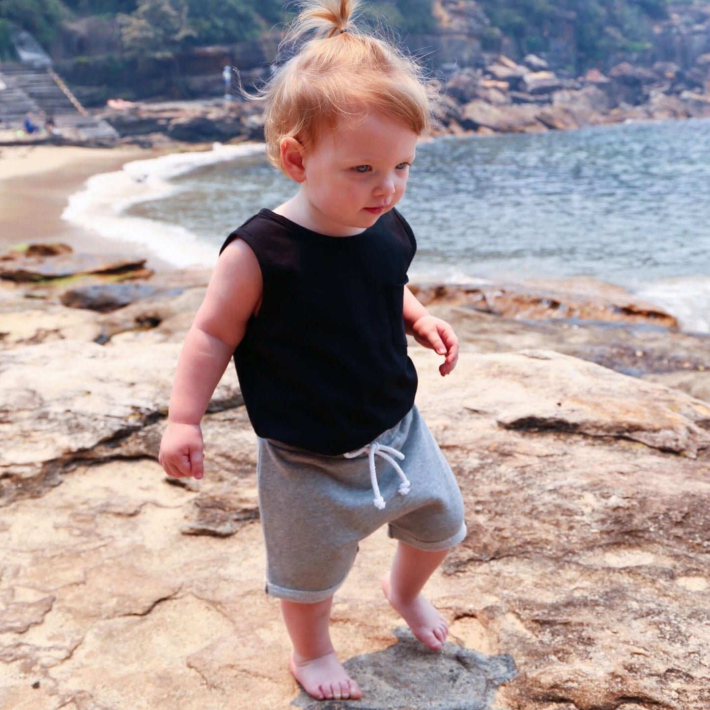 toddler girl wearing black singlet with front pocket. Ethically made in australia with 100% cotton jersey