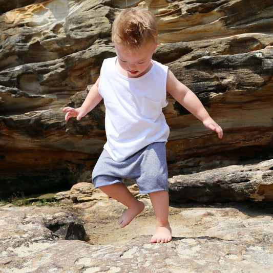 Boy wearing Blue stripe drop crotch shorts with white contrast drawcord and elastic waistband.  Ethically made in Australia with a 100% cotton jersey