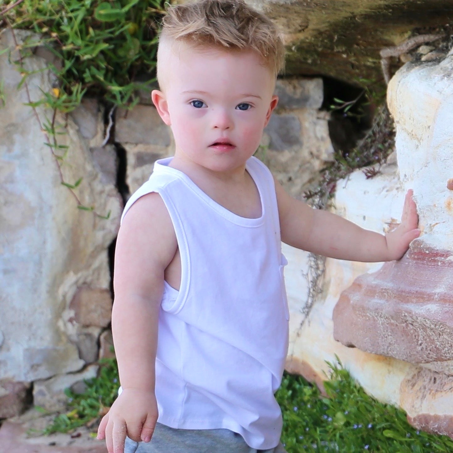 toddler boy wearing white singlet with front pocket. Ethically made in australia with 100% cotton jersey