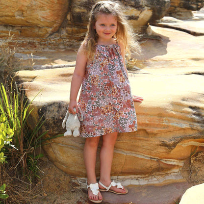 girl wearing floral printed cotton poplin a-line dress with shoulder strap ties.  Ethically made in australia with 100% printed cotton poplin