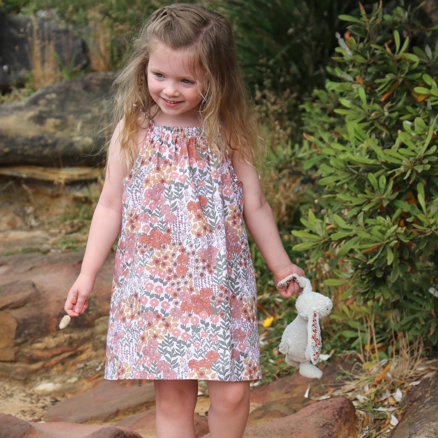 girl wearing floral printed cotton poplin a-line dress with shoulder strap ties.  Ethically made in australia with 100% printed cotton poplin