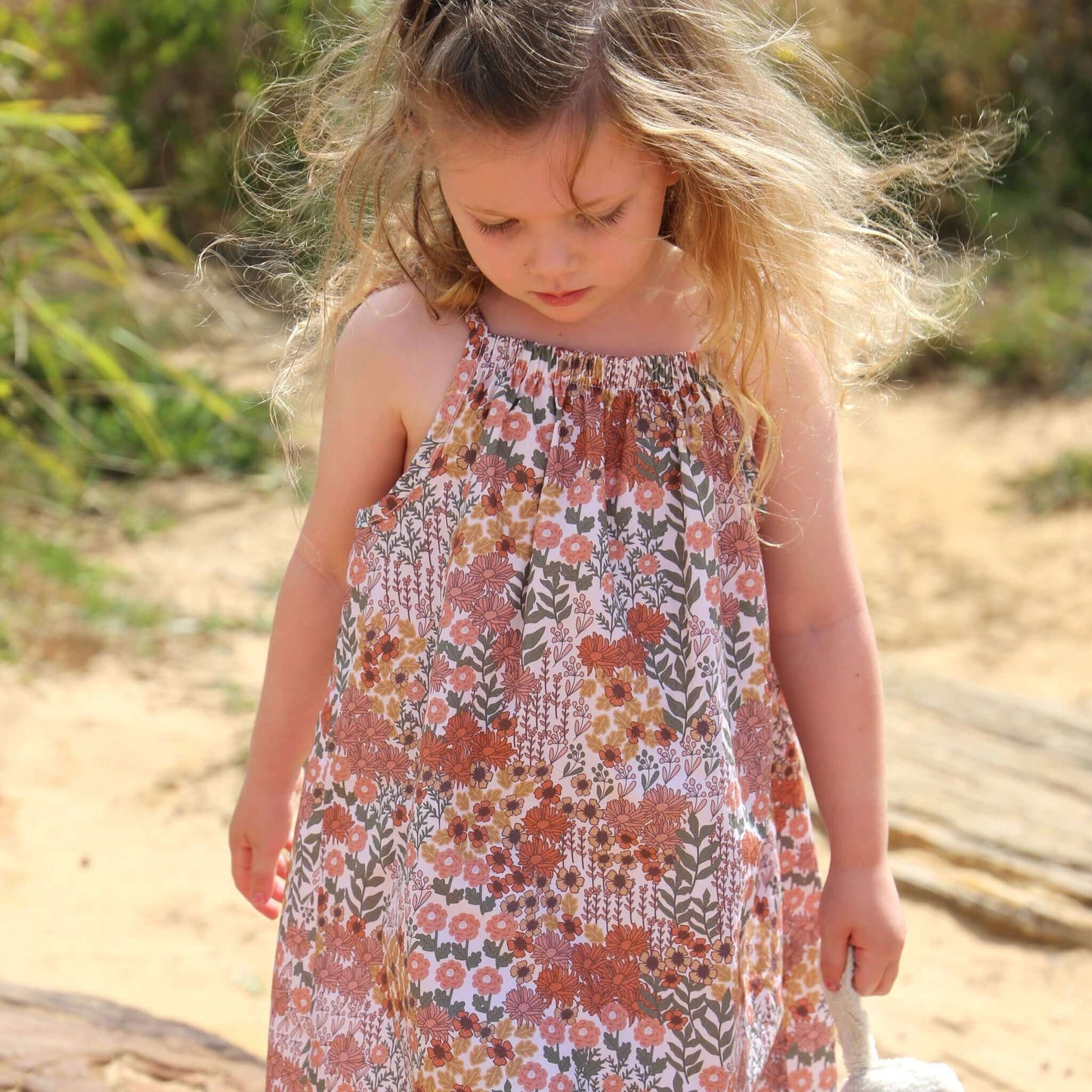 girl wearing floral printed cotton poplin a-line dress with shoulder strap ties.  Ethically made in australia with 100% printed cotton poplin