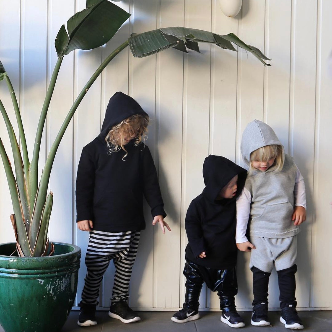 boys wearing black long sleeve hoodie featuring front pouch pocket. Ethically made in australia with 100% cotton french terry