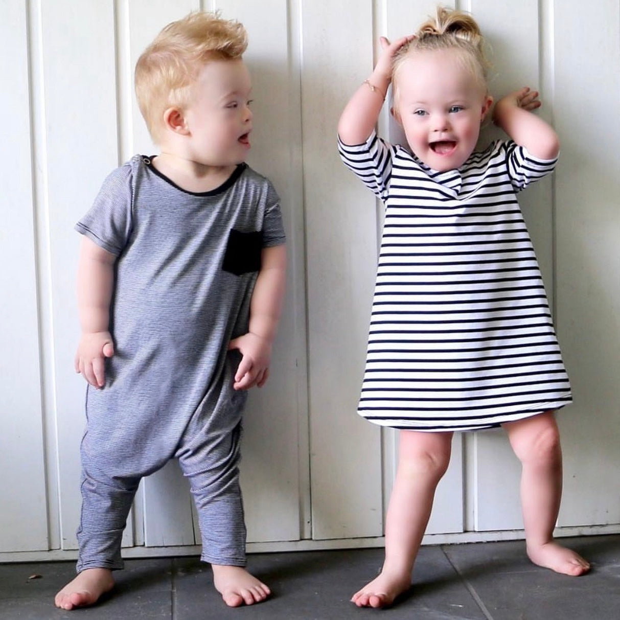 toddler girl wearing white with black stripe casual dress featuring 3/4 sleeves. Ethically made in australia with a cotton/elastane jersey fabric. Dress length sits at knee.