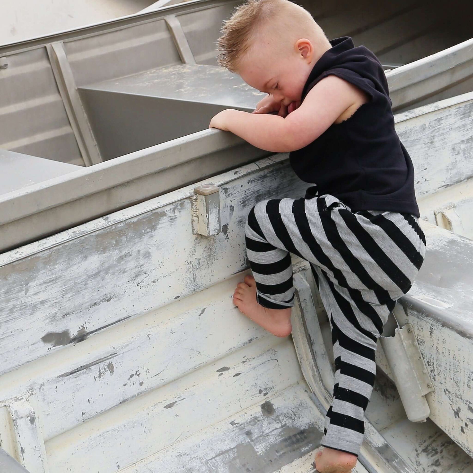 boy wearing grey marle with black stripe harem pant featuring an elastic waistband. Ethically made in australia with a stretch cotton jersey