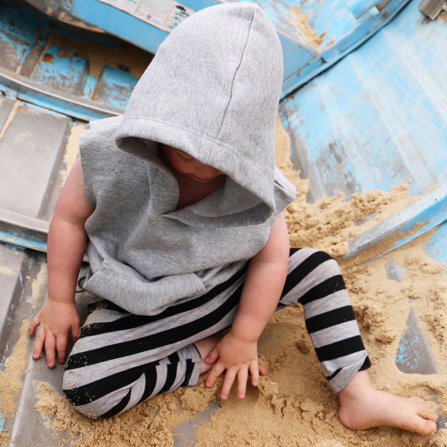 boy wearing grey marle with black stripe harem pant featuring an elastic waistband. Ethically made in australia with a stretch cotton jersey