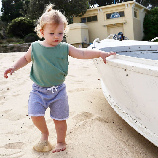 Boy wearing Grey Marle drop crotch shorts with white contrast drawcord and elastic waistband.  Ethically made in Australia with a 100% cotton french terry fabric