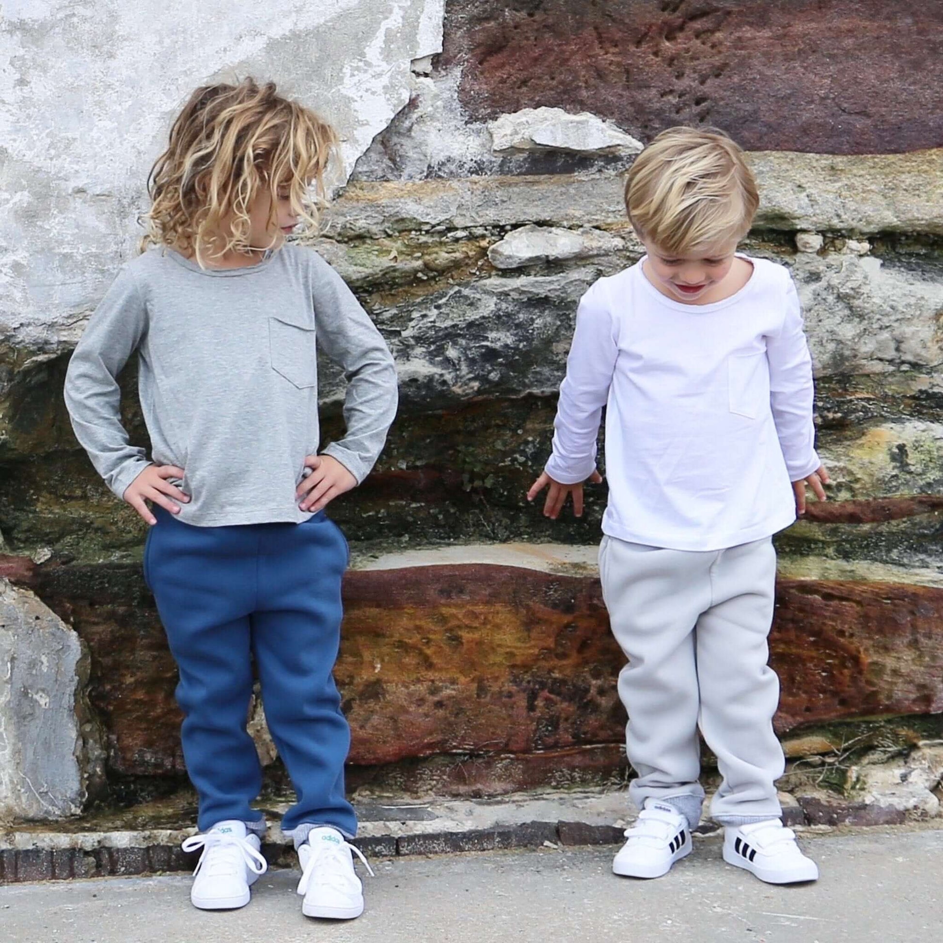 boy wearing long sleeve tshirt featuring front pocket and raw edge neckline. Ethically made in australia with 100% cotton jersey