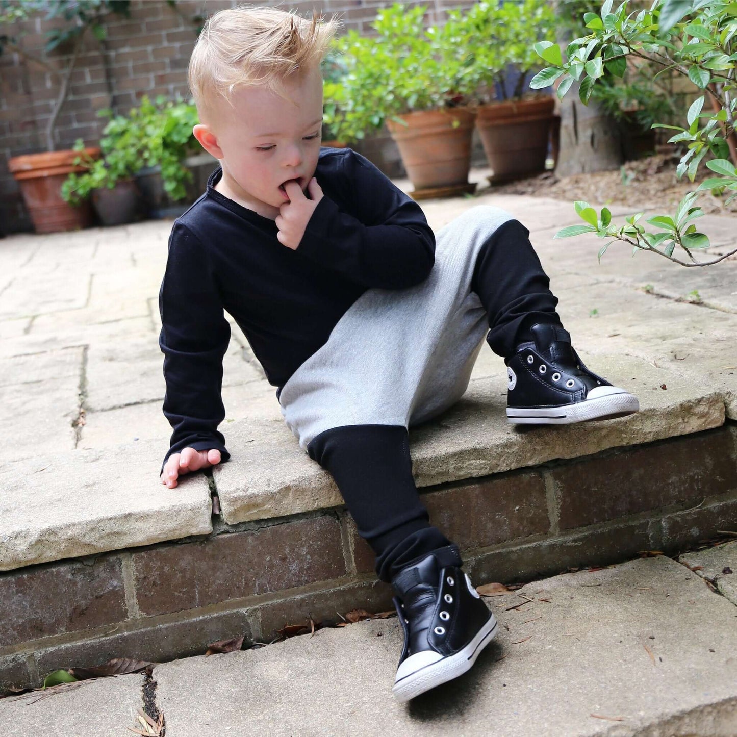 boy wearing grey marle with black contrast harem pant featuring an elastic waistband. Ethically made in australia with 100% cotton french terry and contrast ponte fabric