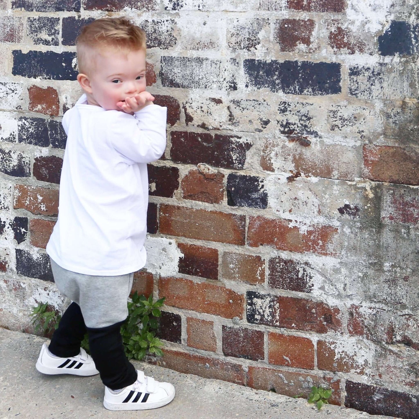 boy wearing grey marle with black contrast harem pant featuring an elastic waistband. Ethically made in australia with 100% cotton french terry and contrast ponte fabric