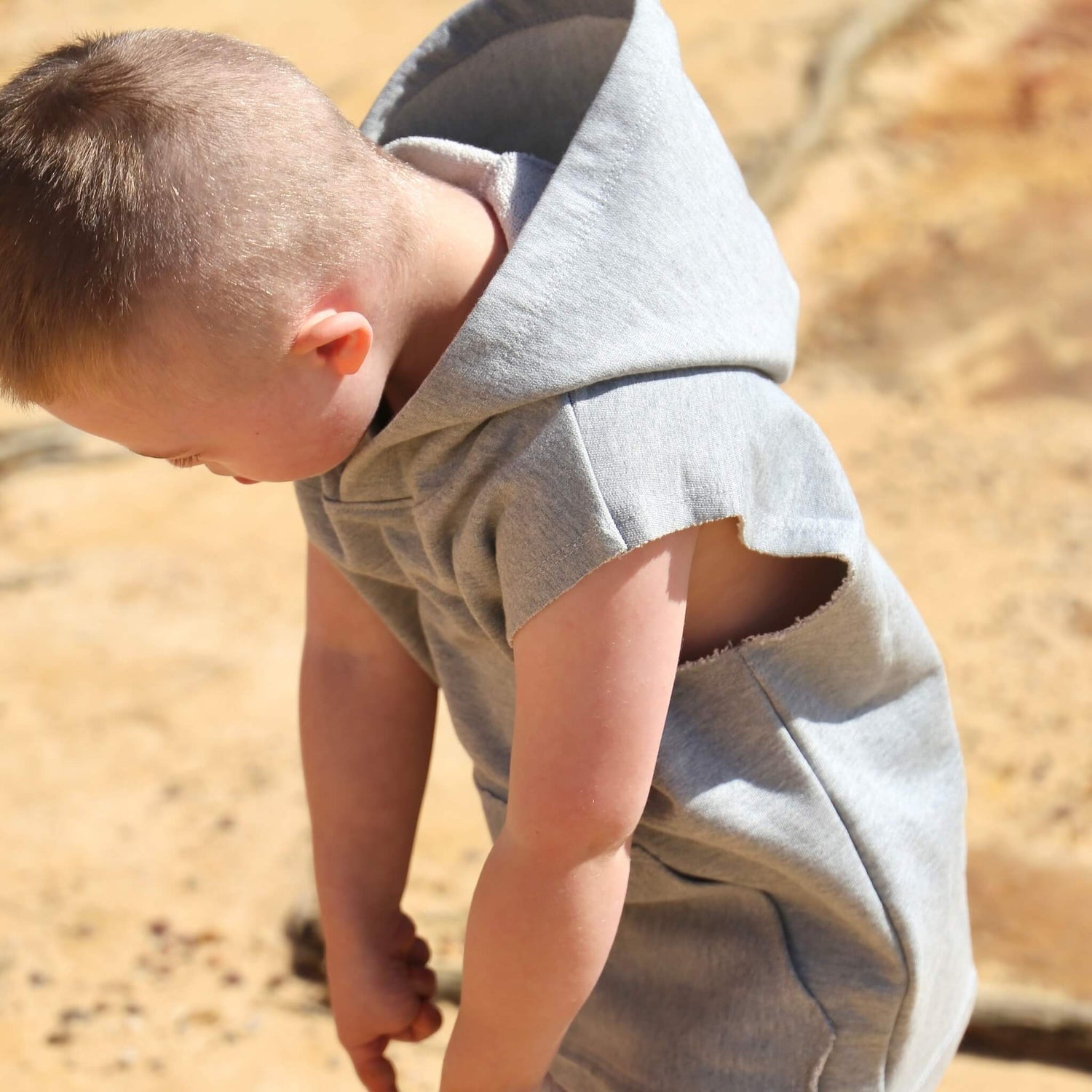 Boy wearing Grey Marle Sleeveless Hoodie ethically made in Australia with 100% Cotton French Terry featuring raw edge armhole and front pouch pocket with raw edges