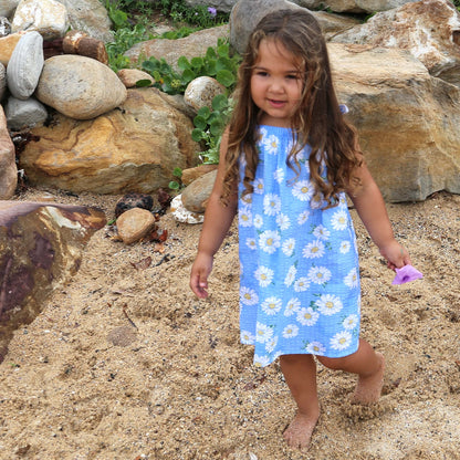 girl wearing blue colour daisy printed summer dress with adjustable tie straps.  Dress made with 100% Cotton printed seersucker