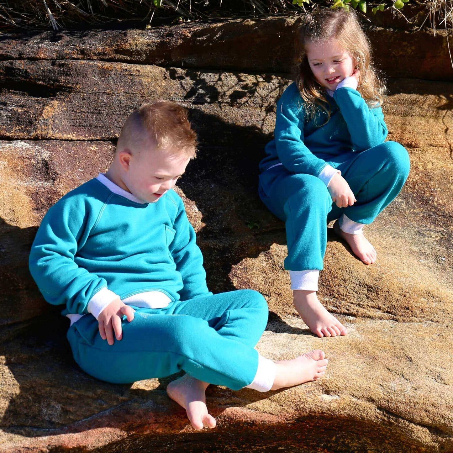 Boy and Girl wearing Jade coloured Winter Sweater featuring White Marle contrast rib at neck, hem and cuff with front pocket ethically made in Australia with Cotton blend cosy and warm Fleece