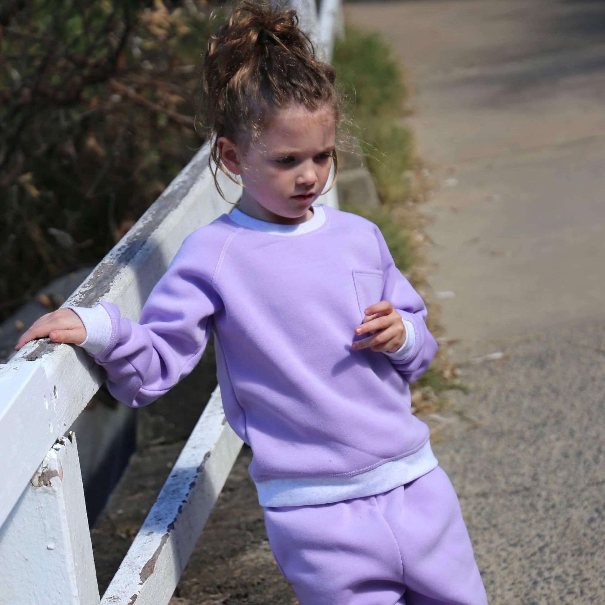 Girl wearing Lilac coloured Winter Sweater featuring White Marle contrast rib at neck, hem and cuff with front pocket ethically made in Australia with Cotton blend cosy and warm Fleece