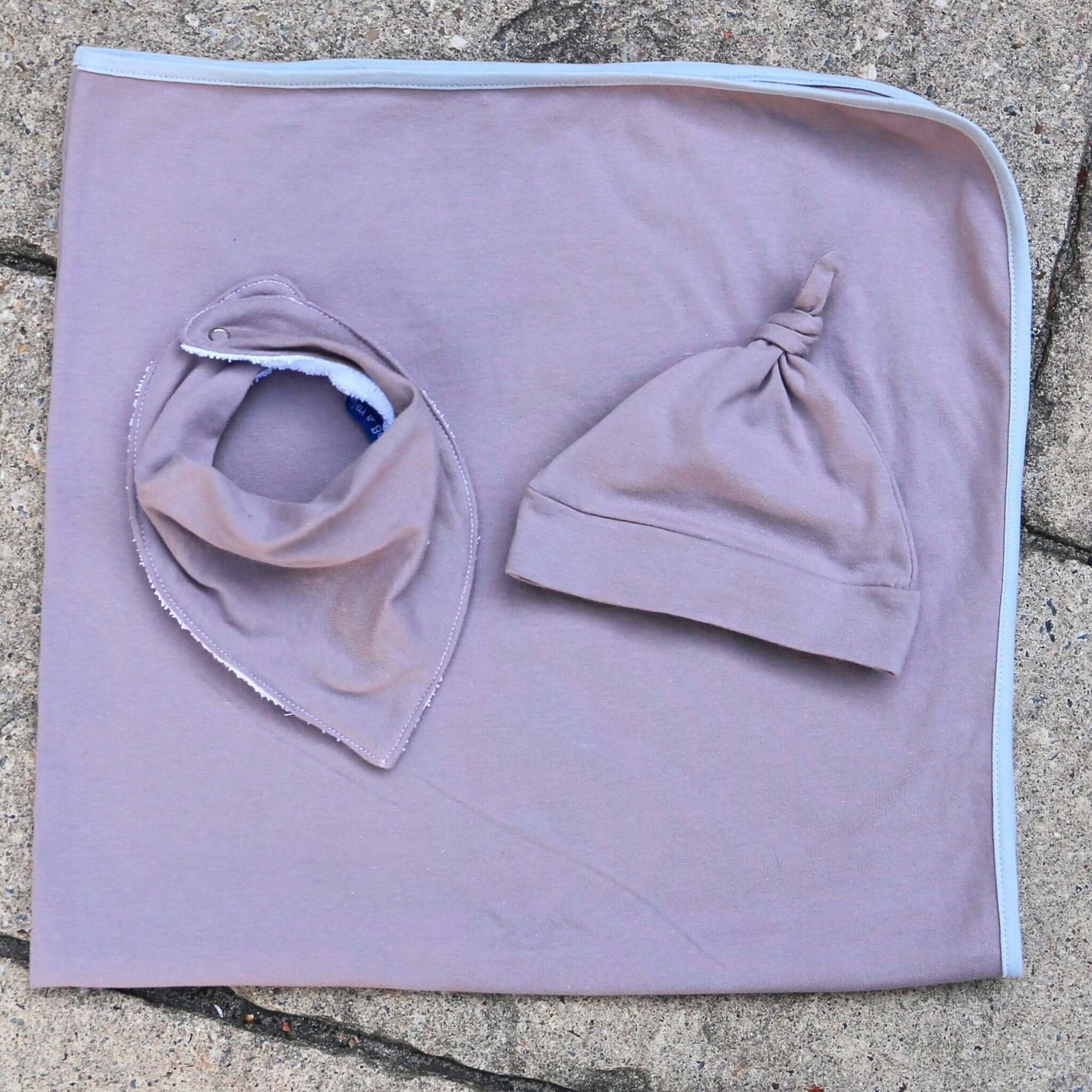 baby wearing musk colour dribble bib. ethically made in australia with 100% cotton jersey and terry towelling lining.