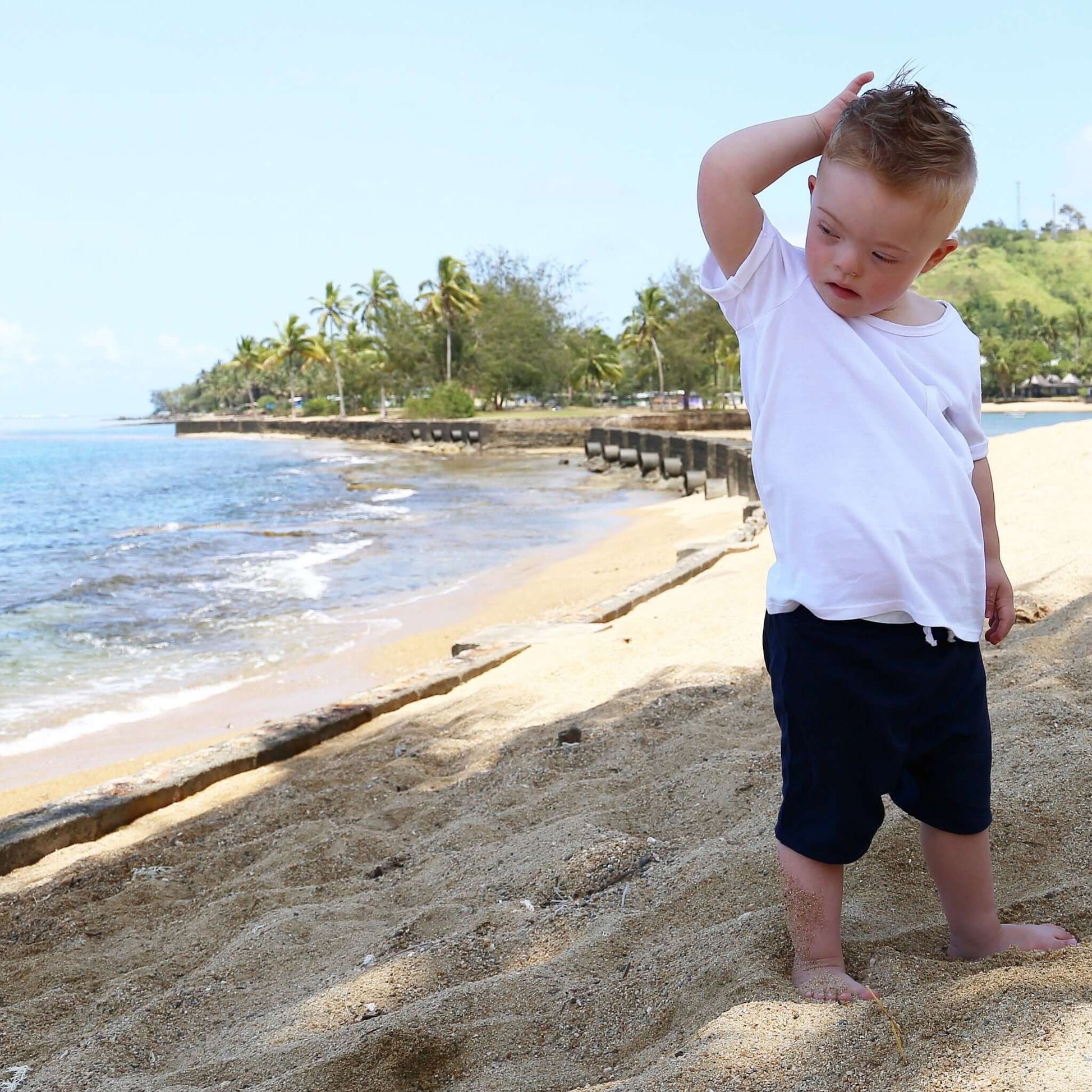 Toddler wearing Navy drop crotch shorts with white contrast drawcord and elastic waistband.  Ethically made in Australia with a 100% cotton soft stretch jersey fabric