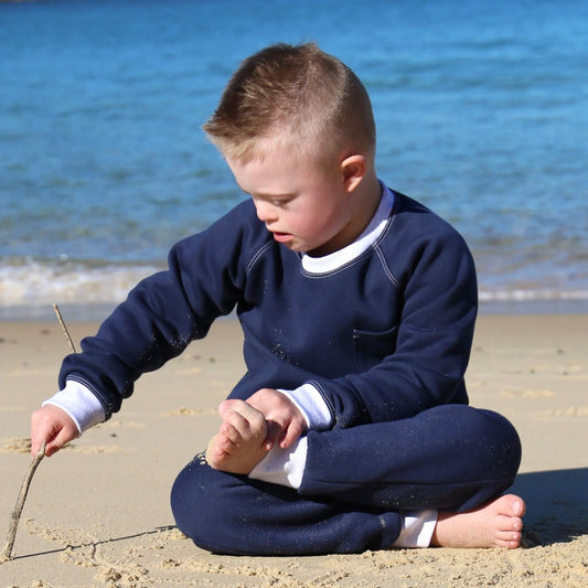 Boy wearing Navy Blue Winter Sweater featuring White Marle contrast rib at neck, hem and cuff with front pocket ethically made in Australia with Cotton blend cosy and warm Fleece