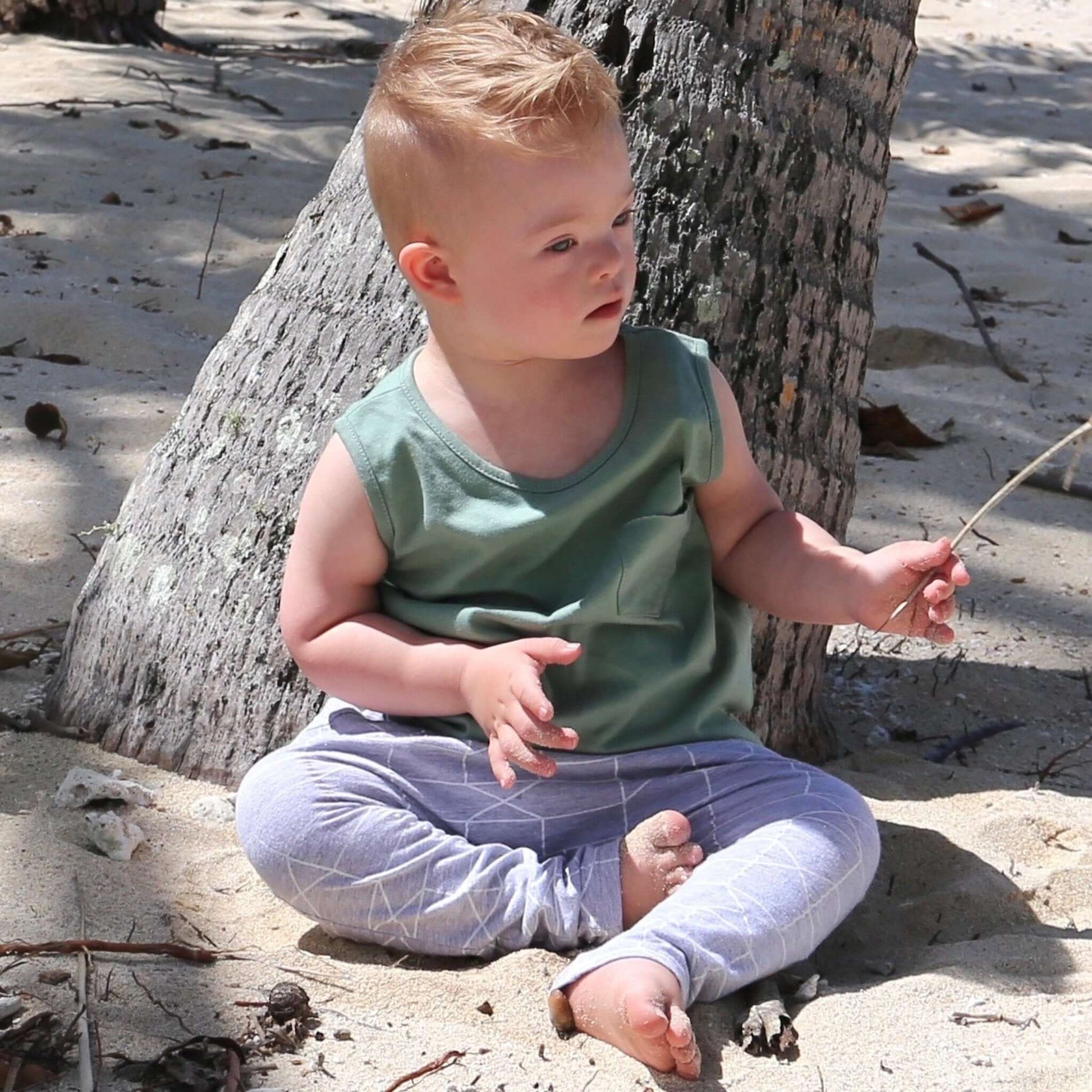 toddler boy wearing sage colour singlet with front pocket. Ethically made in australia with 100% cotton jersey