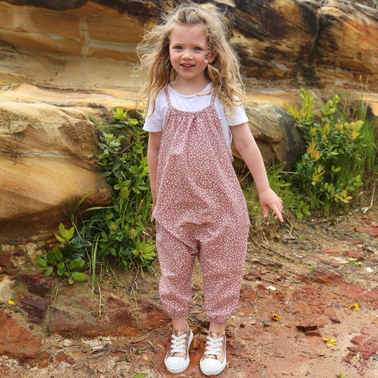 girl wearing antique rose/white spot romper featuring tie straps and elastic leg cuff. ethically made in australia with a linen cotton blend lightweight fabric