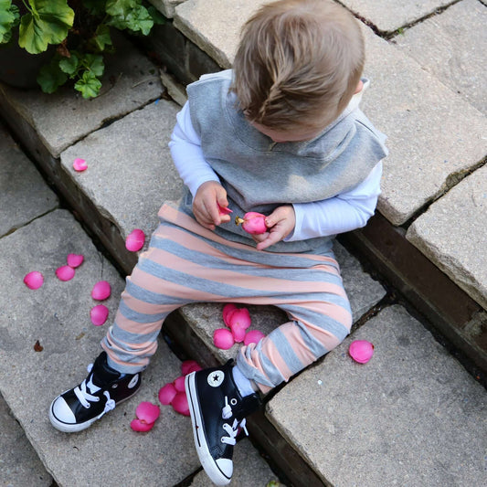 boy wearing peach with grey stripe harem pant featuring an elastic waistband. Ethically made in australia with a stretch cotton jersey