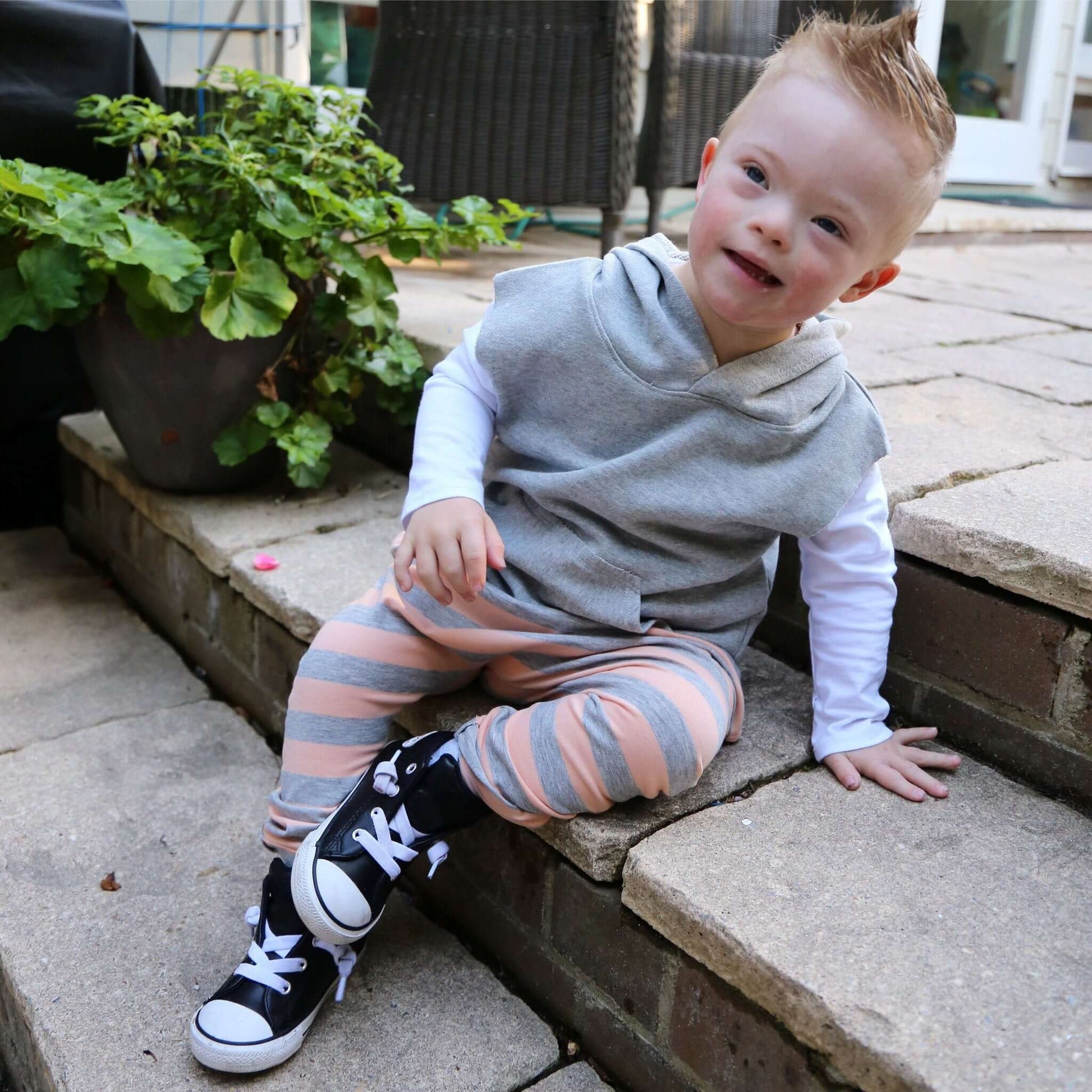 boy wearing peach with grey stripe harem pant featuring an elastic waistband. Ethically made in australia with a stretch cotton jersey