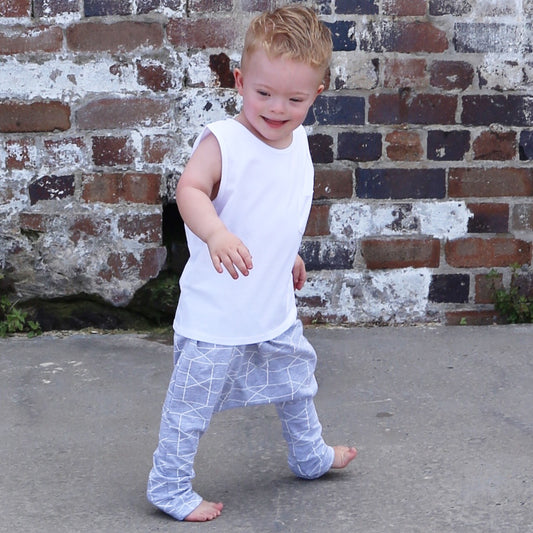 boy wearing grey marle/white printed harem pant featuring an elastic waistband. Ethically made in australia with a stretch cotton jersey